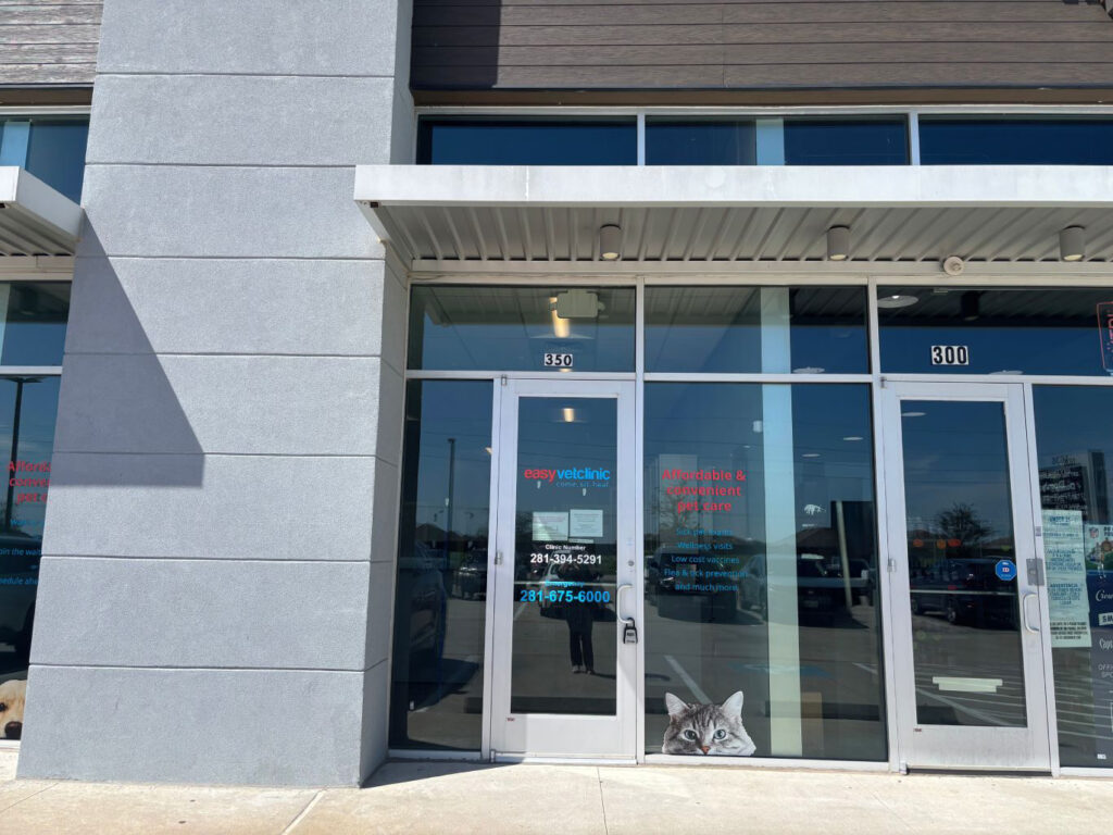 Exterior view of a modern vet clinic with large glass doors and signage.